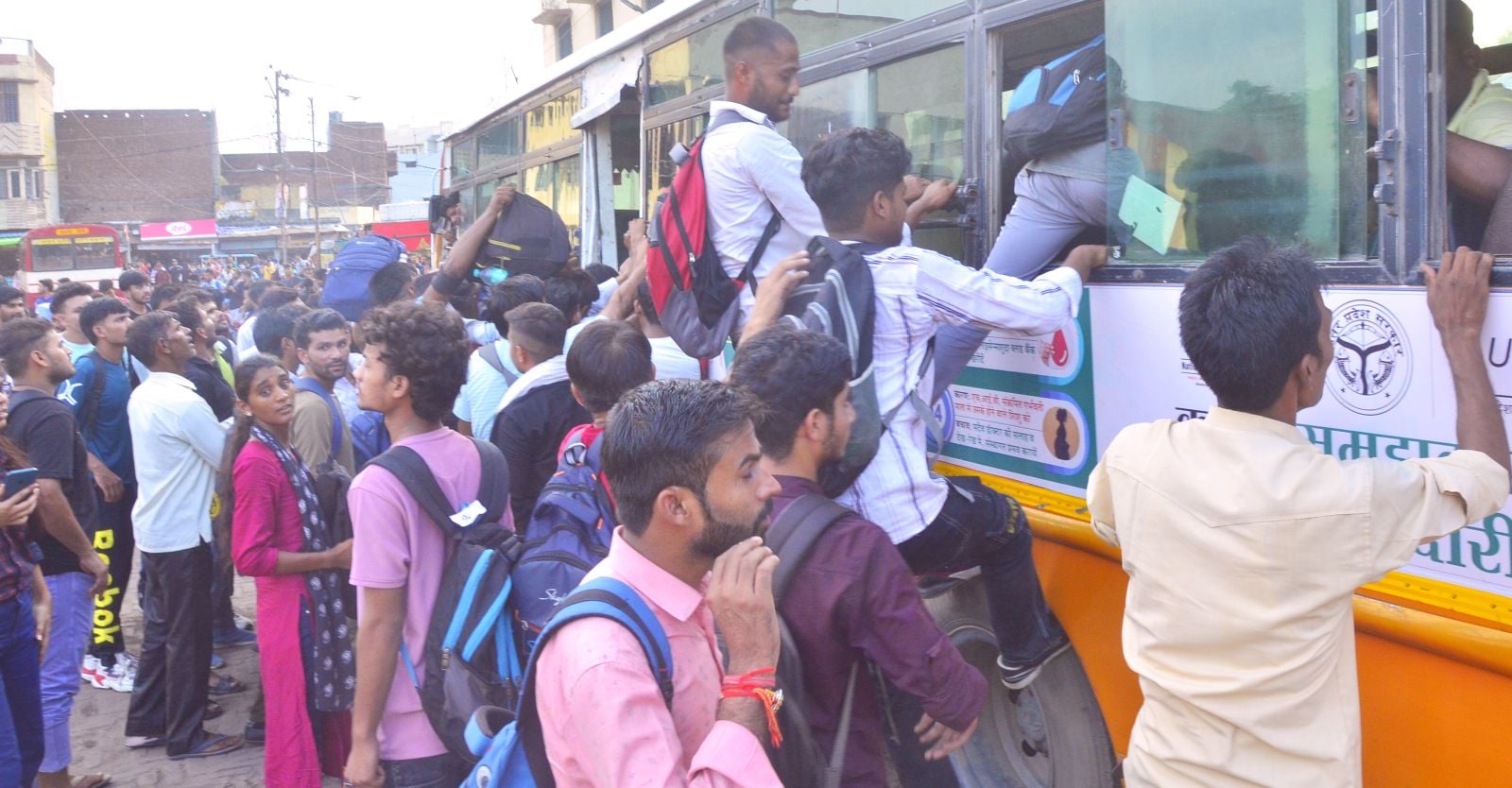 रोडवेज बस स्टैंड पर बस में सीट पाने को खिड़की से चढ़ते अभ्यर्थी। संवाद