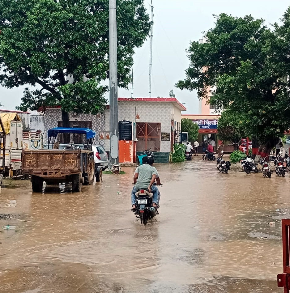 बारिश में छाता लगाकर जाती युवती। संवाद