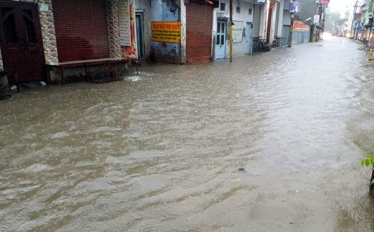 बारिश में छाता लगाकर जाती युवती। संवाद