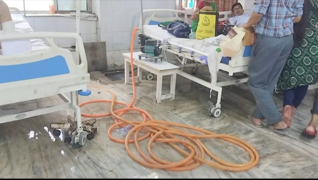 अस्पताल परिसर में भरे पानी से गुजरते मरीज अस्पताल परिसर में भरे पानी से गुजरते मरीज