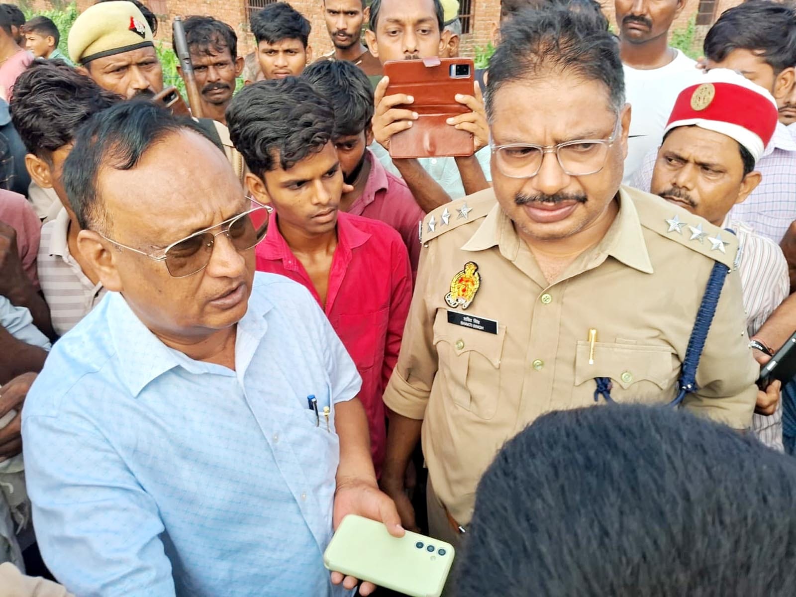 उझानी में चोरों को ले जाते समय पुलिस की जीप को घेरे खड़े ग्रामीण। उझानी में चोरों को ले जाते समय पुलिस की जीप को घेरे खड़े ग्रामीण।