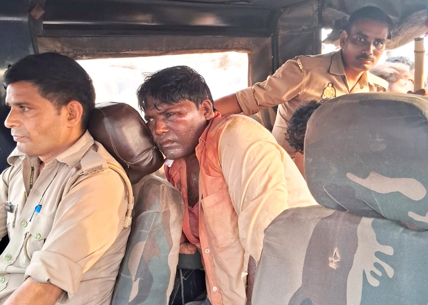 उझानी में चोरों को ले जाते समय पुलिस की जीप को घेरे खड़े ग्रामीण। उझानी में चोरों को ले जाते समय पुलिस की जीप को घेरे खड़े ग्रामीण।