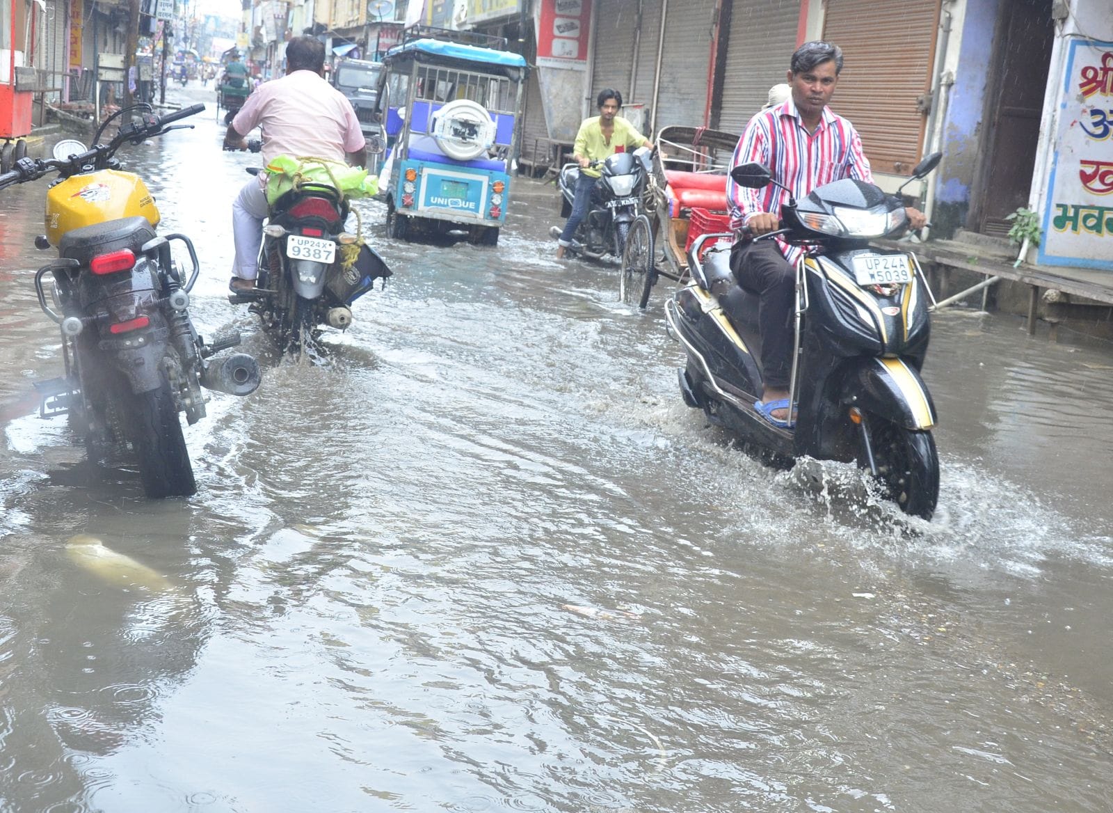दुकान के आगे जमा कींचड़ को हटाता दुकानदार। संवाद दुकान के आगे जमा कींचड़ को हटाता दुकानदार। संवाद