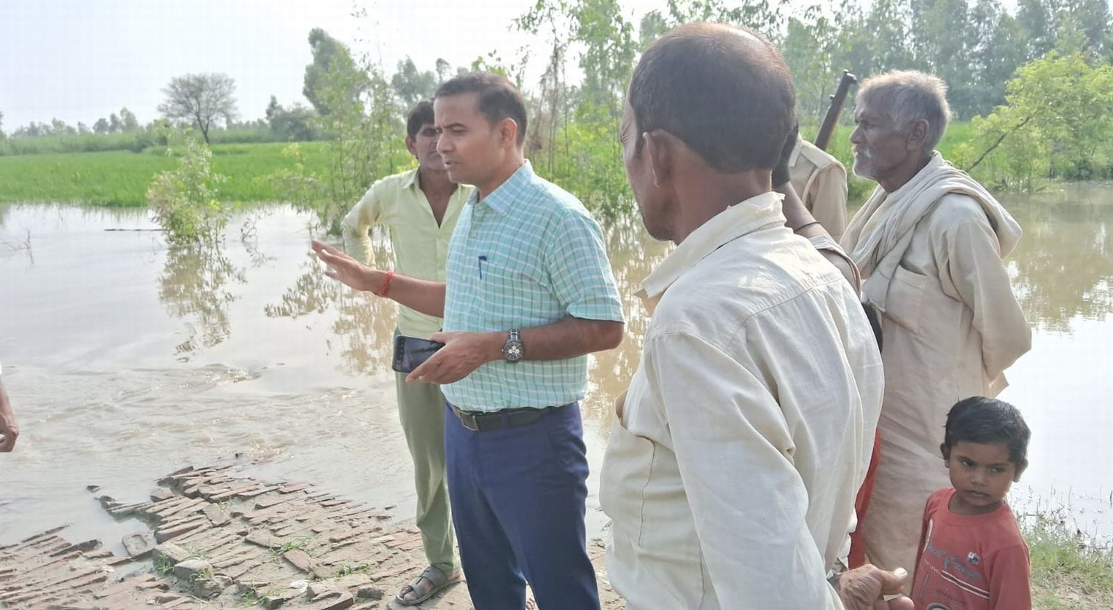 बाढ़ के पाना से होकर निकलते नगरिया खनू के लोग। संवाद बाढ़ के पाना से होकर निकलते नगरिया खनू के लोग। संवाद