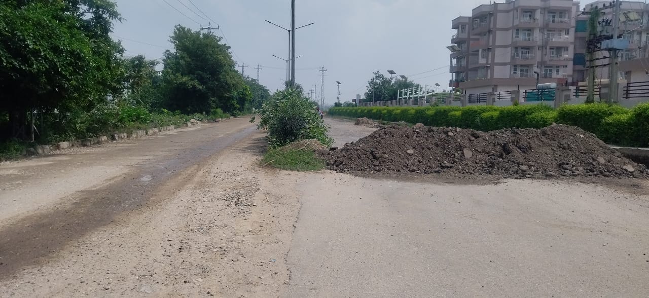 कुरुक्षेत्र। उमरी रोड पर सड़क में पड़े गहरे गड्ढों से बारिश का जमा हुआ पानी निकालता हुआ एक मजदू