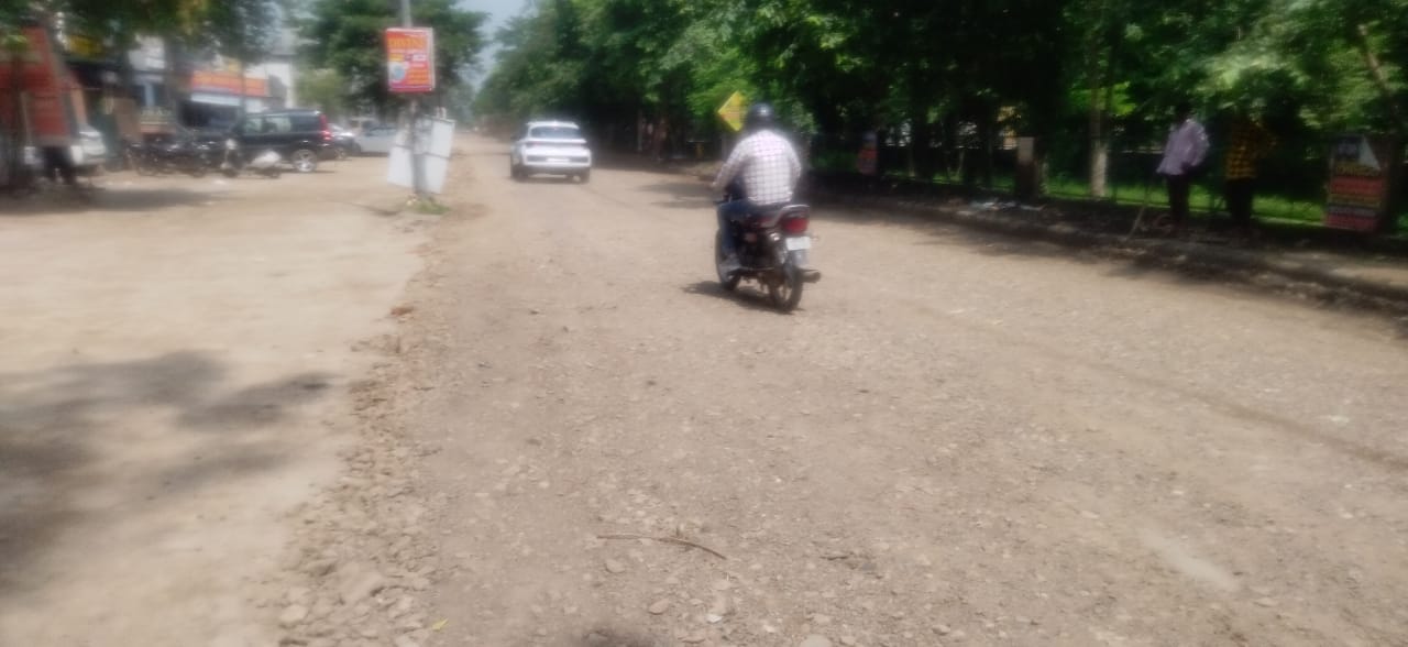 कुरुक्षेत्र। उमरी रोड पर सड़क में पड़े गहरे गड्ढों से बारिश का जमा हुआ पानी निकालता हुआ एक मजदू