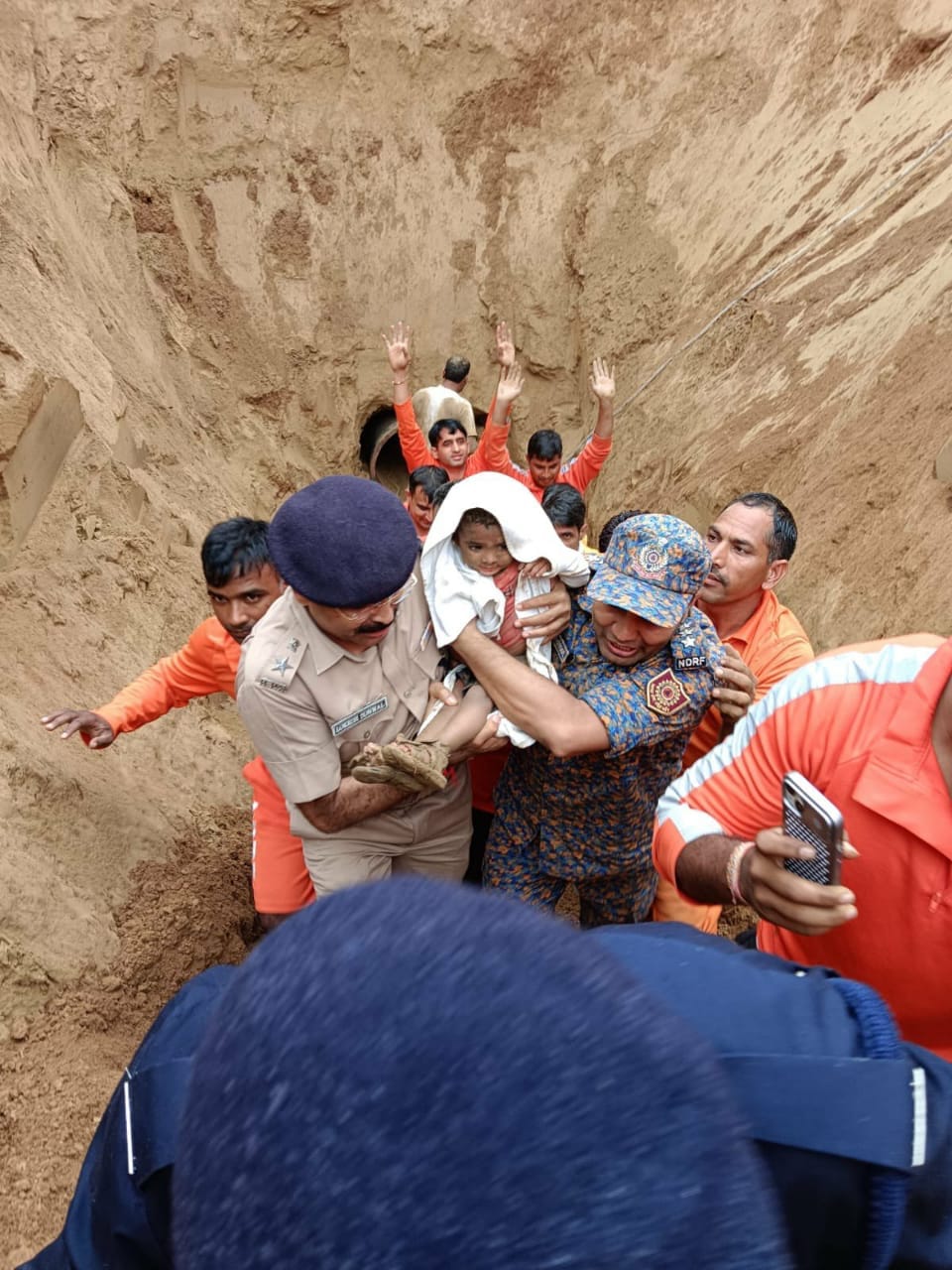 ढाई साल की मासूम नीरू को बोरवेल से बाहर लाते हुए जिला कलेक्टर देवेंद्र कुमार और बचाव टीम