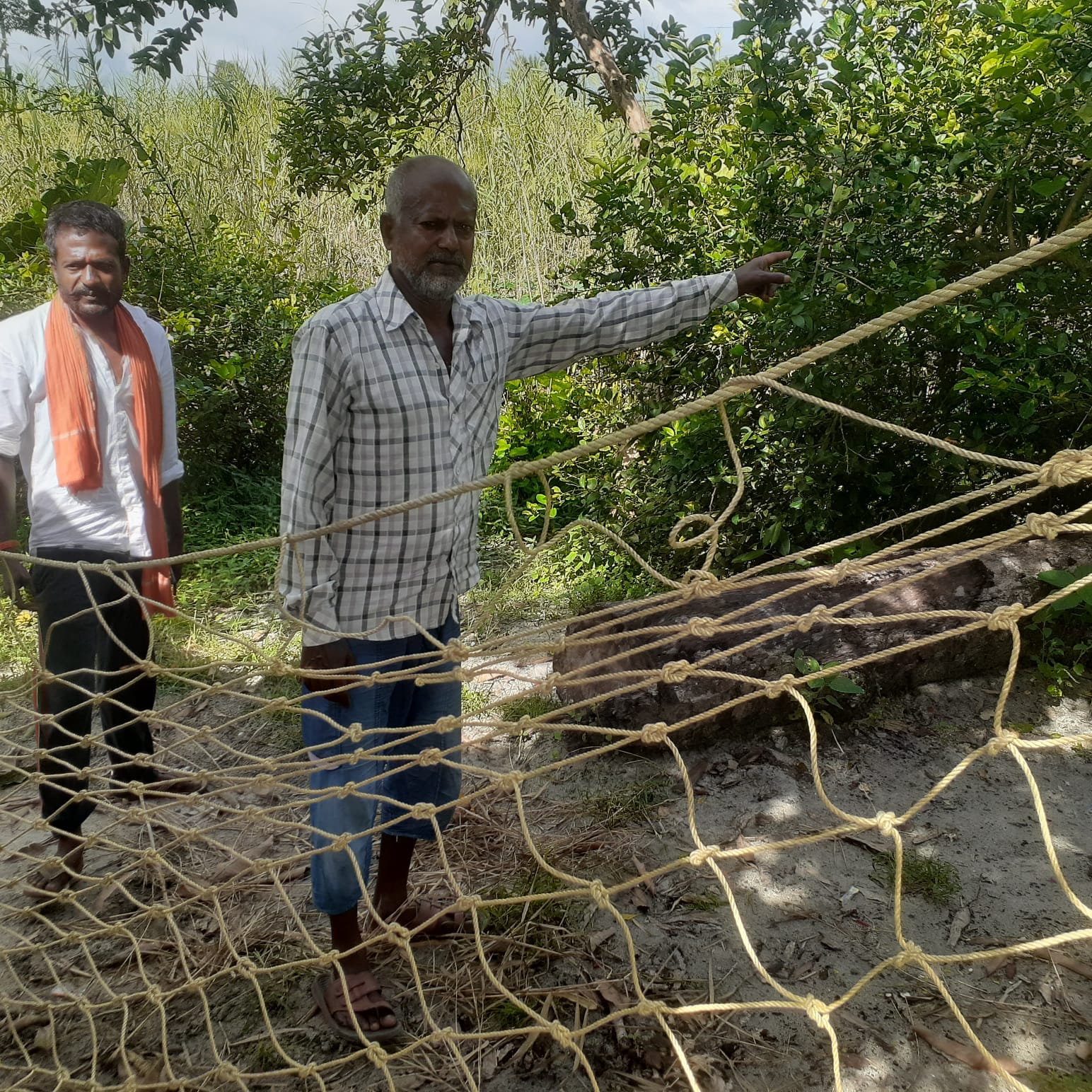शारदा डैम की तलहटी में पिंजरे के पास खड़े ग्रामीण।संवाद