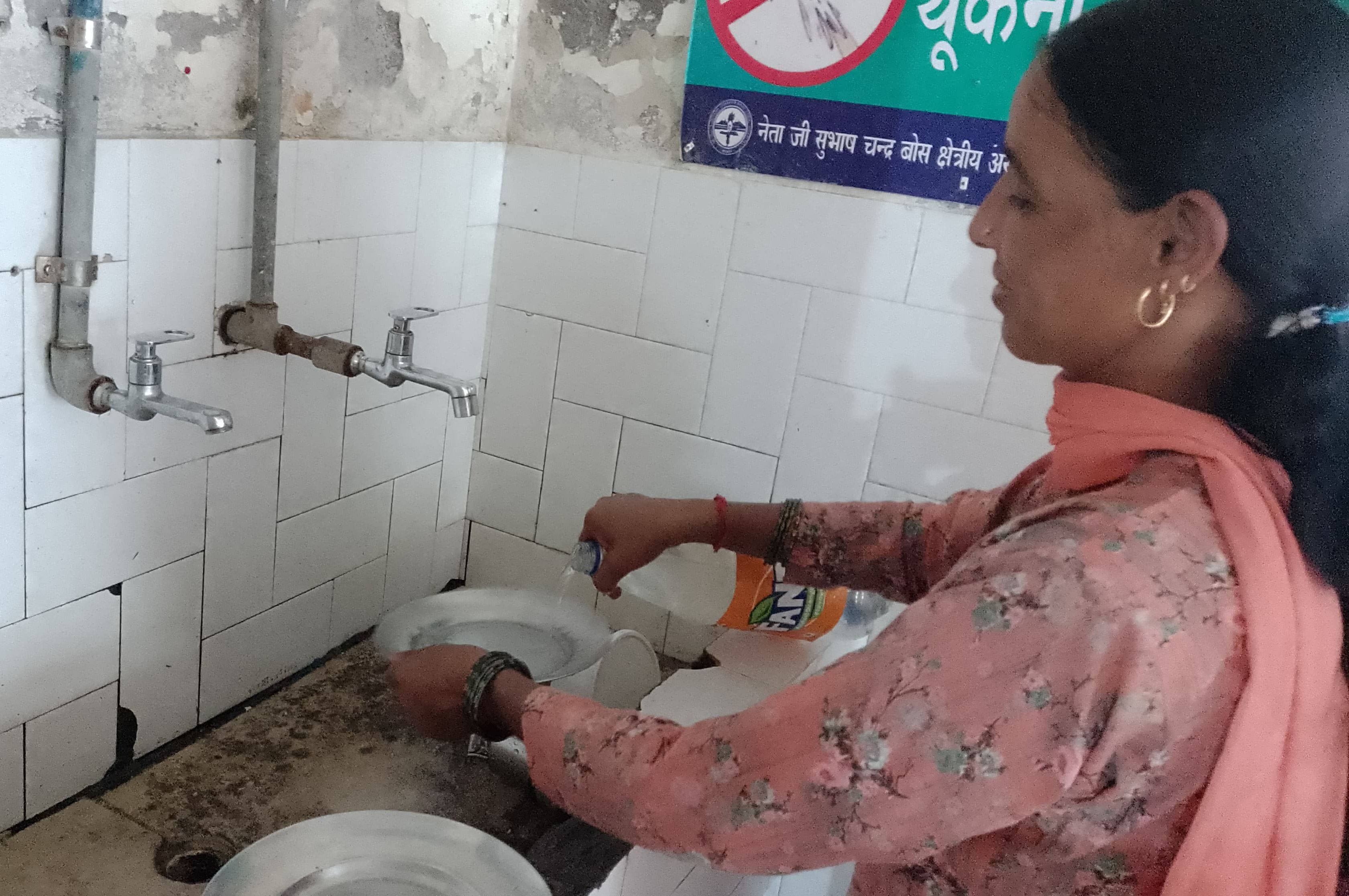 जोनल अस्पताल मंडी  के वार्डों में पेयजल न होने पर बाहर लगे कूलर से पानी भरती तीमारदार महिला। सं