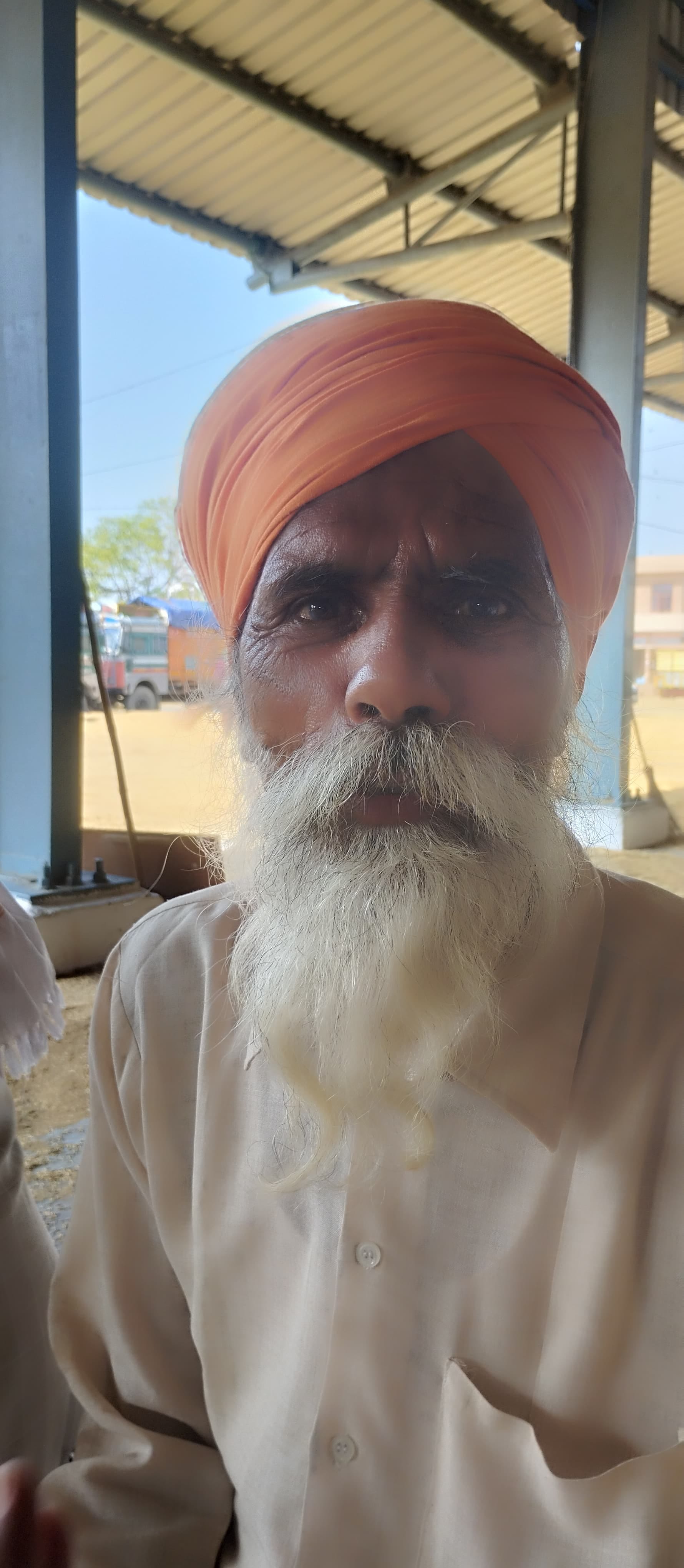 स्थान न होने के कारण मंडी की सड़क पर धान उतारते हुए किसान। स्थान न होने के कारण मंडी की सड़क पर