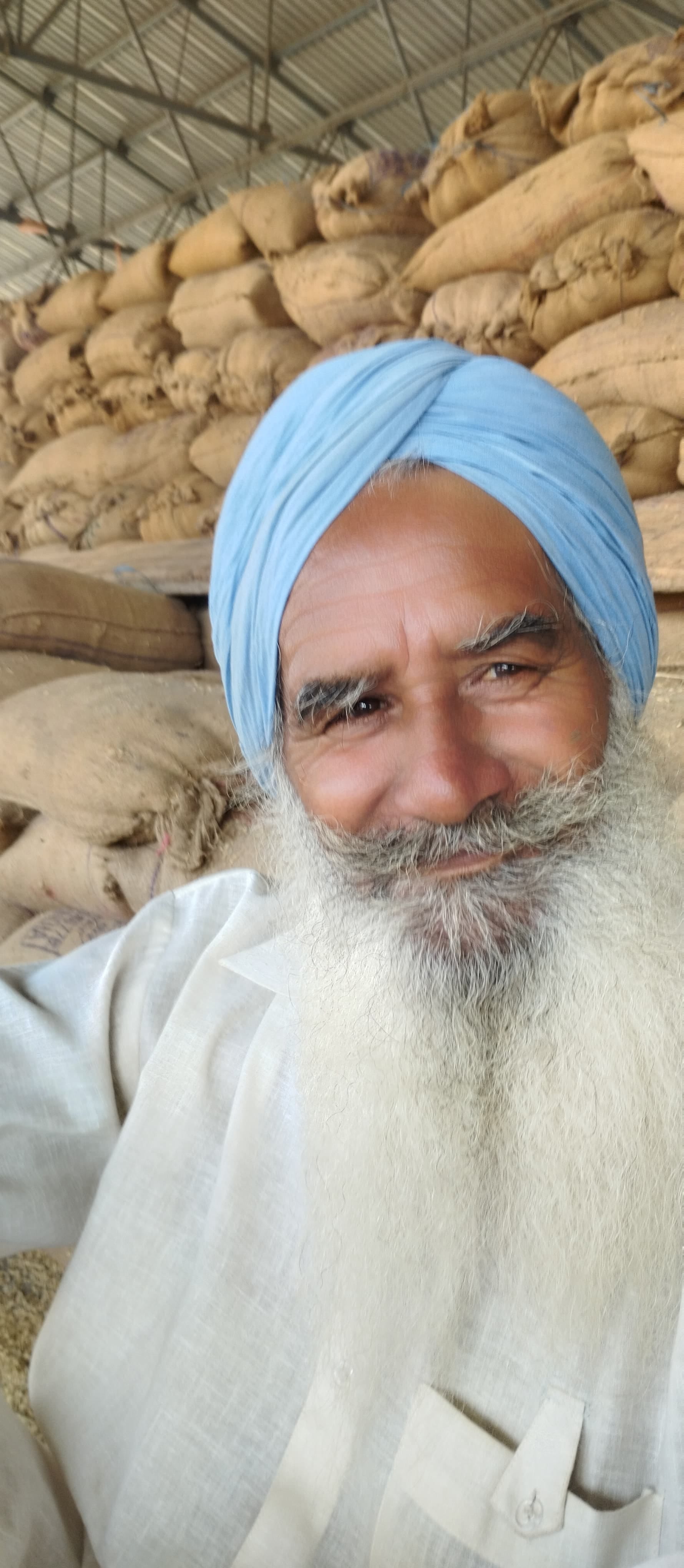 स्थान न होने के कारण मंडी की सड़क पर धान उतारते हुए किसान। स्थान न होने के कारण मंडी की सड़क पर