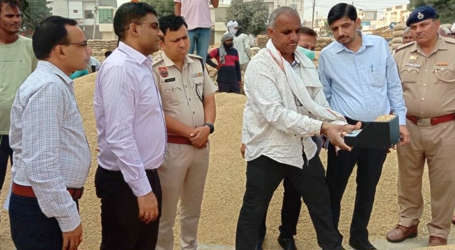 14जेएनडी24-धान की ढेरी पर मीटर से नमी की जांच करते हुए डीसी मोहम्मद इमरान रजा। संवाद