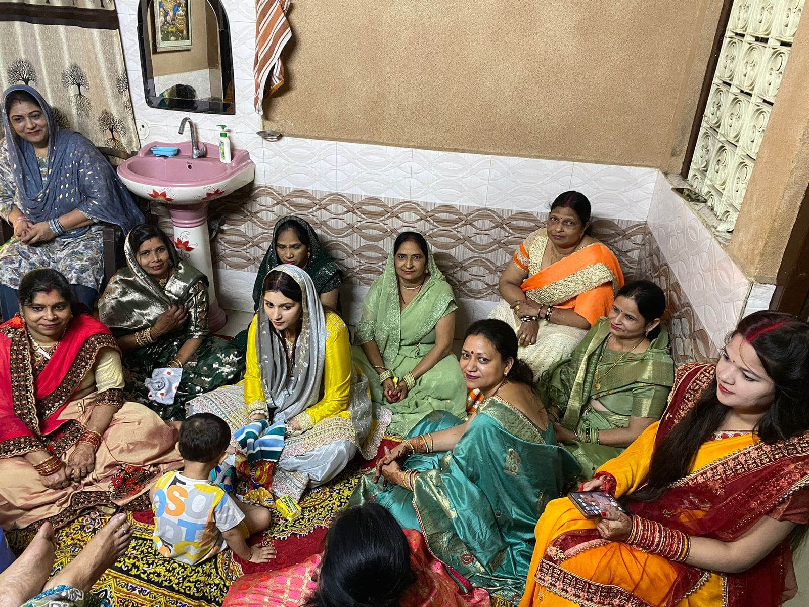 ऊन  में  करवा चौथ के व्रत की कथा सुनती  महिलाएं। संवाद