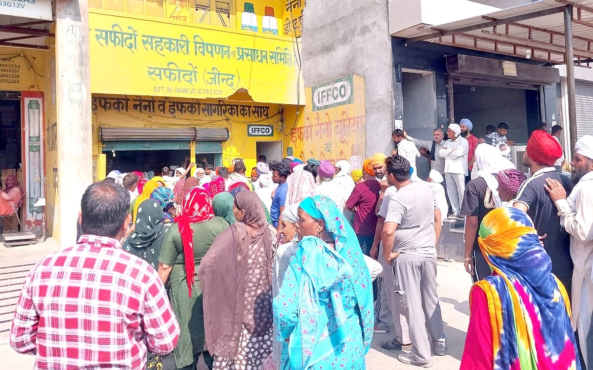 24जेएनडी24: खाद के साथ दी जा रही शीशी को दिखाता हुआ एक किसान। संवाद
