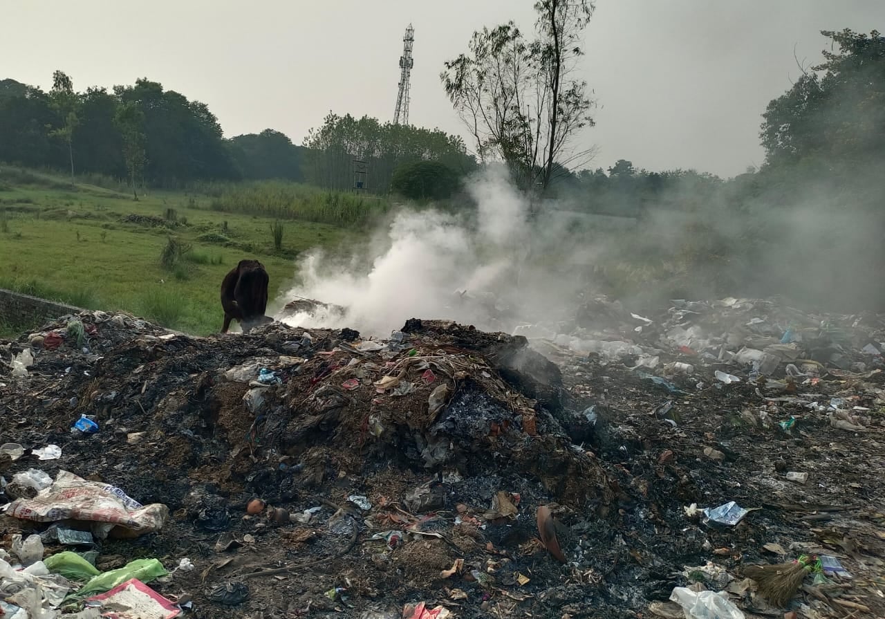 बस अड्डे के सामने लगे कूड़े के ढेर से उठता धुंआ  संवाद