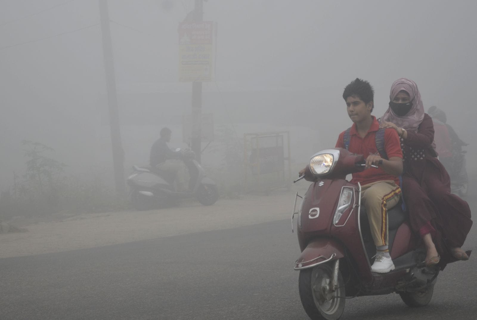 बुद्धवार को सुबह घने कोहरे के बीच निकलते दो पहिया वाहन। संवाद
