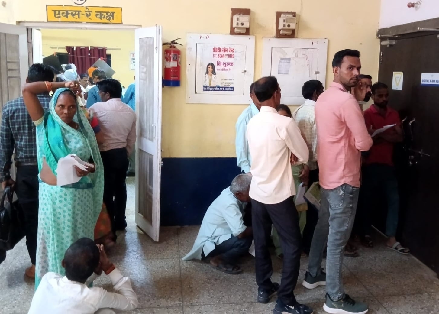 पीलीभीत के जिला चिकित्सालय में टूटी बेंच पर बैठे लोग।संवाद पीलीभीत के जिला चिकित्सालय में टूटी बेंच पर बैठे लोग।संवाद