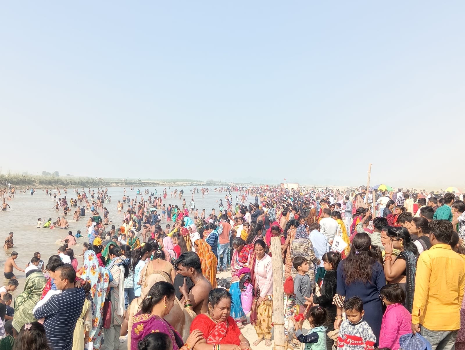पीलीभीत के ब्रहमचारी घाट पर बच्चे को कंधे पर बैठालकर स्नान कराता श्रद्धालु।संवाद पीलीभीत के ब्रहमचारी घाट पर बच्चे को कंधे पर बैठालकर स्नान कराता श्रद्धालु।संवाद