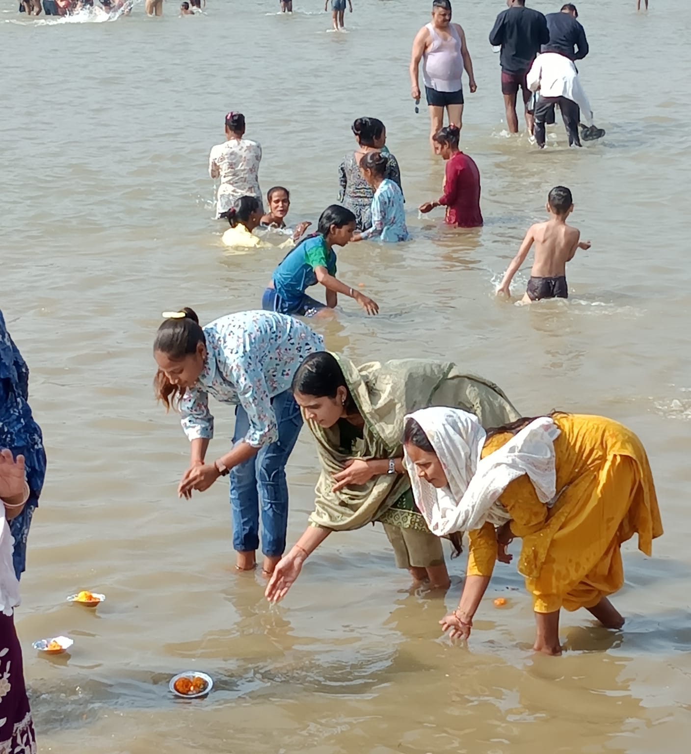 पीलीभीत के ब्रहमचारी घाट पर बच्चे को कंधे पर बैठालकर स्नान कराता श्रद्धालु।संवाद पीलीभीत के ब्रहमचारी घाट पर बच्चे को कंधे पर बैठालकर स्नान कराता श्रद्धालु।संवाद