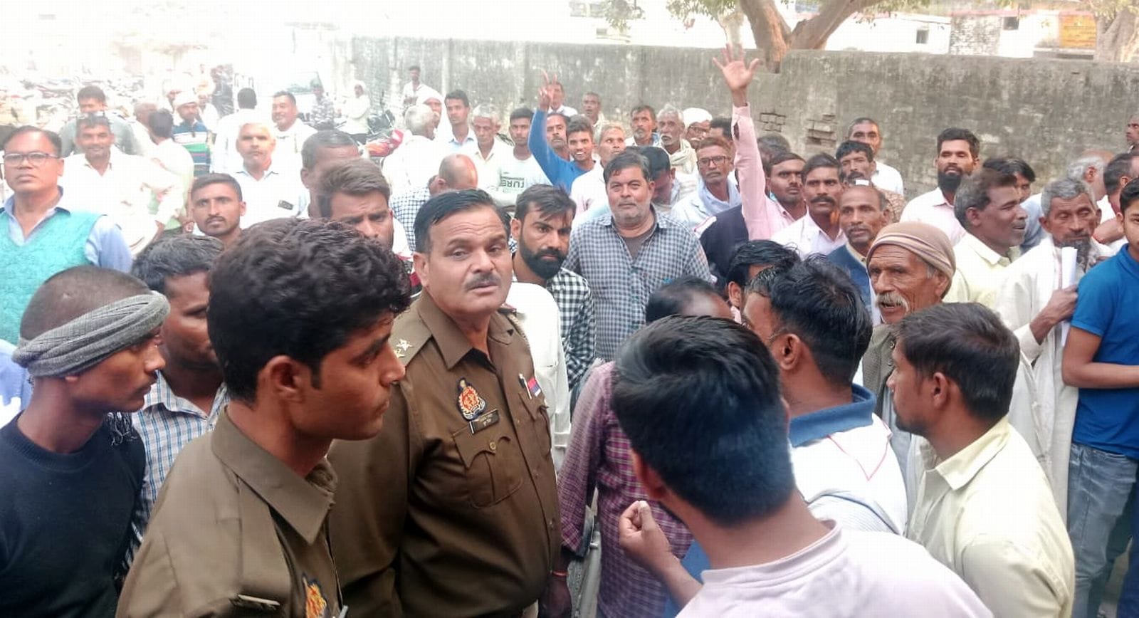 उझानी में पुलिस की मौजूदगी में लगी किसानों की लाइन। संवाद उझानी में पुलिस की मौजूदगी में लगी किसानों की लाइन। संवाद