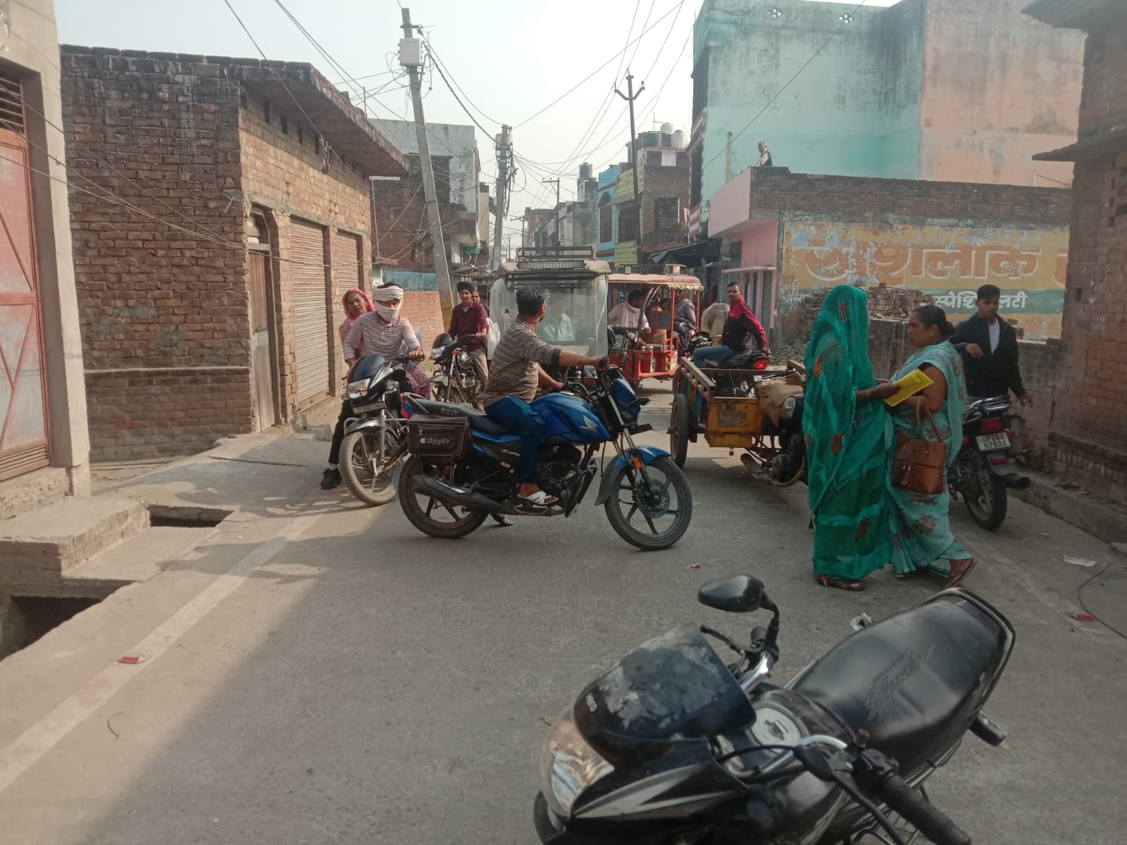 पूरनपुर की जायसवाल कॉलोनी में क्षतिग्रस्त लाइन सही करते कर्मचारी।संवाद