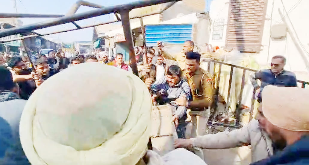 अतिक्रमण हटाने पहुंची टीम का विरोध करने वाले रेहड़ी चालक को खदेड़ते थाना प्रभारी प्रहलाद सिंह। 