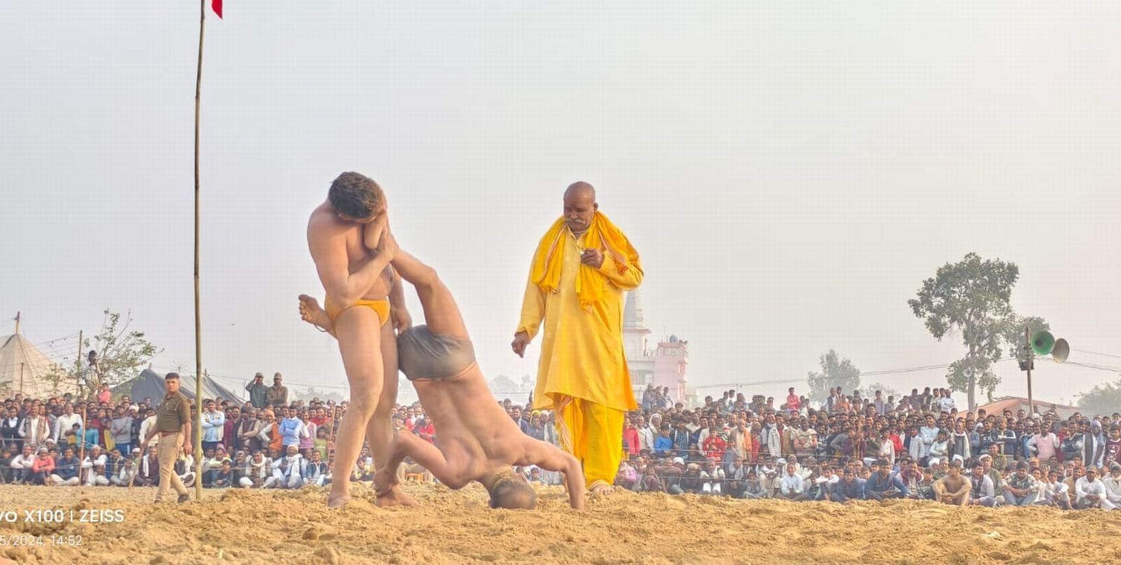 पहलवानों का हाथ मिलाकर दंगल का शुभारंभ करते मेला मालिक मयंक गुप्ता व अन्य। संवाद