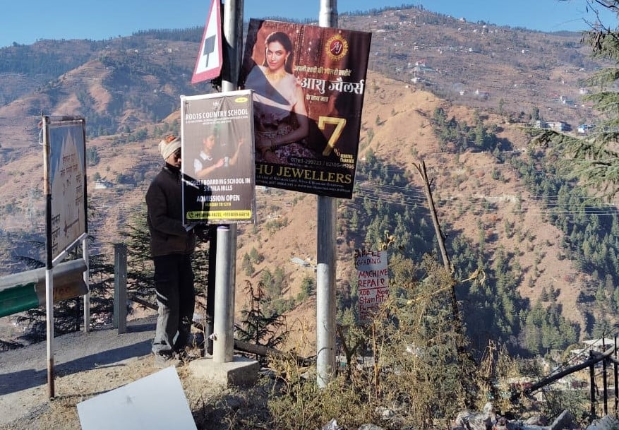 रोहडू शिमला मार्ग पर कोटखाई में सड़क के किनारे से पोस्टर बेनर हटाते पुलिस के जवान व मजदूर