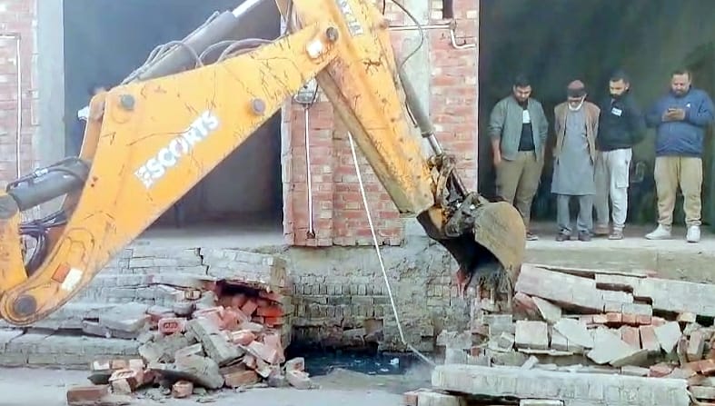 संभल में सांसद के घर की सीढि़यों को तोड़ती जेसीबी। संवाद
