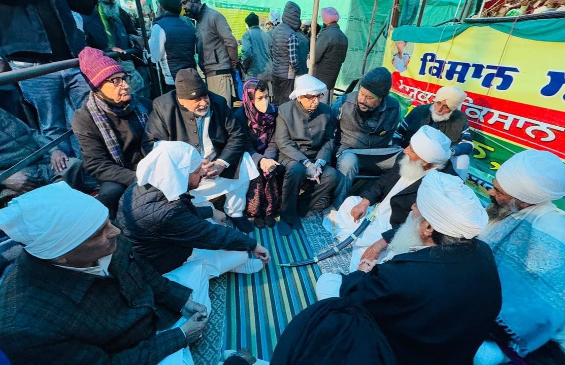 बारिश के दौरान तंबू से निकलते किसान। स्रोत :  किसान