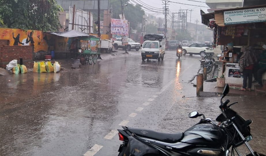 कांधला मोहल्ला खेल से बरसात के भरे पानी से होकर जाते छात्र