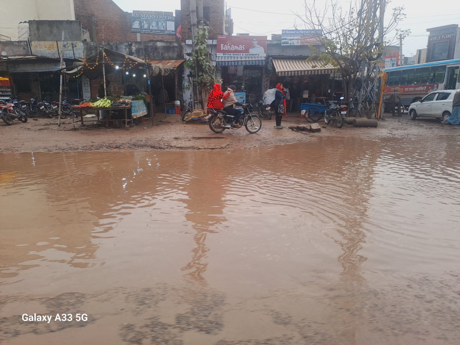 अंबाला में हो रूक रूक कर हो रही बरसात से बच्चे को कुछ इस तरह से उठाकर आता व्यक्ति। संवाद