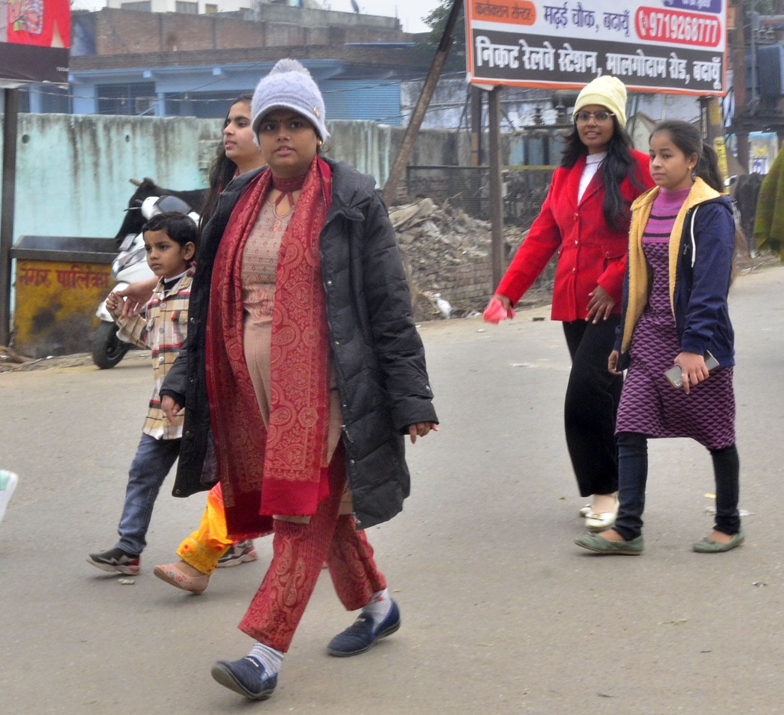 बढ़ती ठंड में गर्म कपड़ों में पथिक चौक से गुजरतीं युवतियां। संवाद