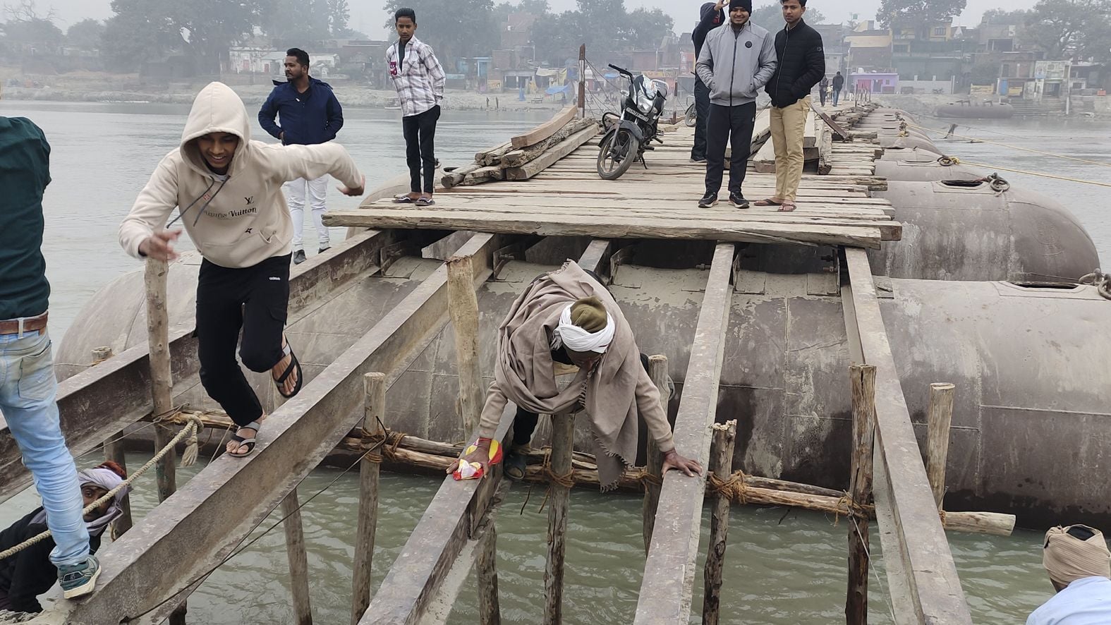 पांचाल घाट पर बने पैंटून पुल से जान जोखिम में डालकर निकलते लोग। पांचाल घाट पर बने पैंटून पुल से जान जोखिम में डालकर निकलते लोग।