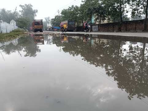 पीलीभीत में बृहस्पतिवार की सुबह रिमझिम बारिश में छाता लगाकर जाती छात्राएं।संवाद