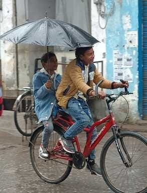 पीलीभीत में बृहस्पतिवार की सुबह रिमझिम बारिश में छाता लगाकर जाती छात्राएं।संवाद