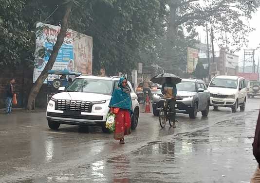 पीलीभीत में बृहस्पतिवार की सुबह रिमझिम बारिश में छाता लगाकर जाती छात्राएं।संवाद