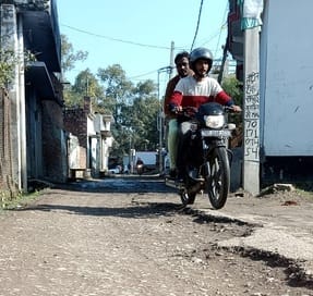 पीलीभीत के मोहल्ला मोहम्मद वासिल की खस्ताहाल सड़क से गुजरता राहगीर।संवाद पीलीभीत के मोहल्ला मोहम्मद वासिल की खस्ताहाल सड़क से गुजरता राहगीर।संवाद