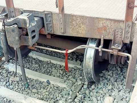 दुर्घटनाग्रस्त मालगाड़ी और सुधार कार्य करते रेलवे अधिकारी