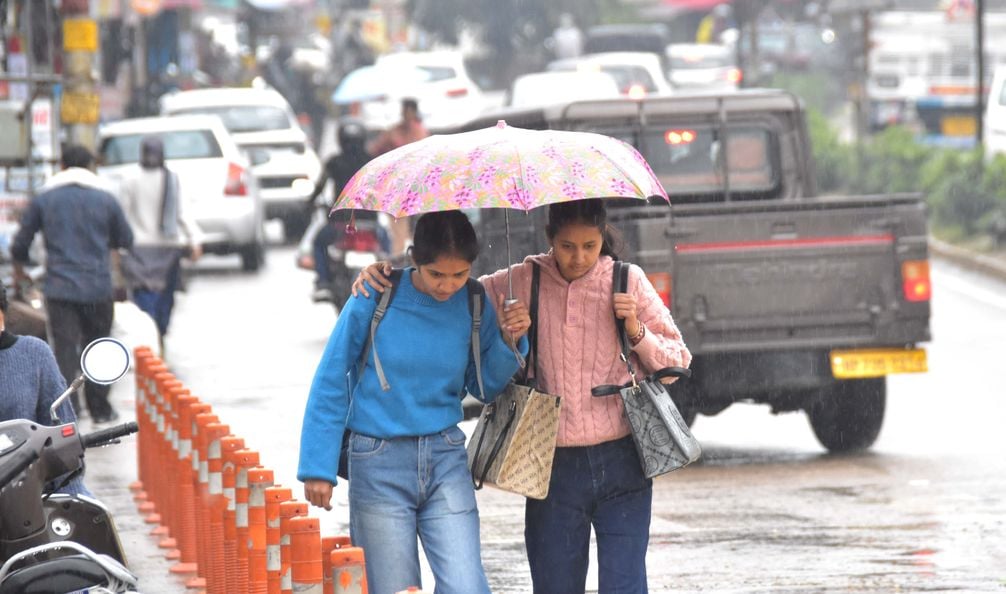 बैग न गिला हो जाए... ऊना में बारिश से बचने के लिए स्कूली छात्राओं से अपने कोट से ढके बैग की कित