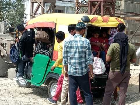 शहर के असम चौराहे के पास वाहन के इंतजार में खड़े लोग।संवाद शहर के असम चौराहे के पास वाहन के इंतजार में खड़े लोग।संवाद