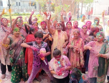 शहर की कृष्ण विहार कॉलोनी में होली खेलते लोग।संवाद