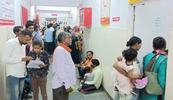 शहर के जिला चिकित्सालय में पर्चा बनाने वाले काउंटर पर लगी लोगों की लंबी लाइन।संवाद