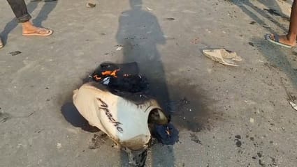 दुर्घटना के बाद बाइक टंकी में लगी आग, घटनास्थल पर मौजूद लोगों की भीड़, ट्रक में फंसी बाइक