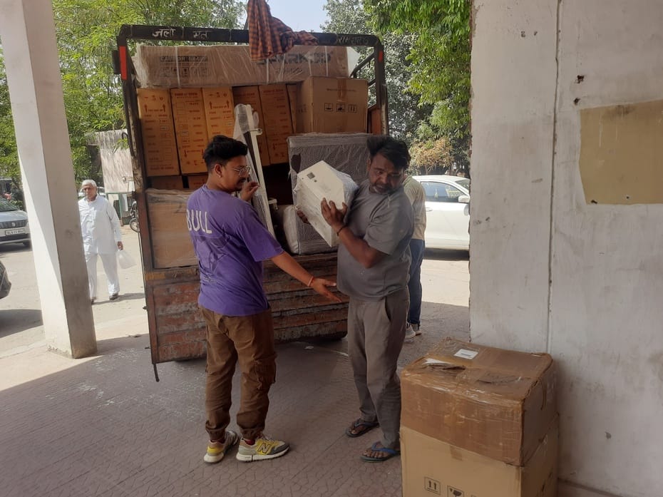 फोटो 03. सोनीपत के सिविल सर्जन कार्यालय में गाड़ी से फिजियोथैरेपी मशीनों को उतारते मजदूर। संवाद