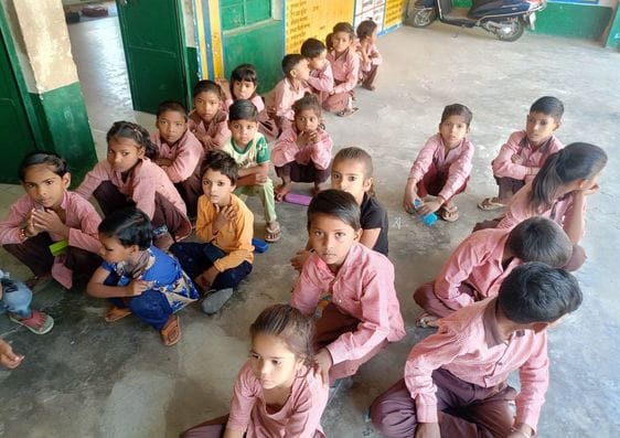 प्राथमिक विद्यालय बनिया में पट्टी पर बैठे बच्चे। संवाद
