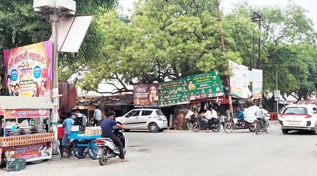 पुवायां में राजीव चौक पर राजीव गांधी की प्रतिमा के ऊपर और भगवान कृष्ण के चित्र के आगे लगी होर्ड