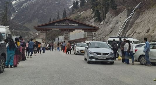 अटल टनल के नोर्थ पोर्टल में बर्फ की वादियों में फोटो लेते सैलानी। संवाद।