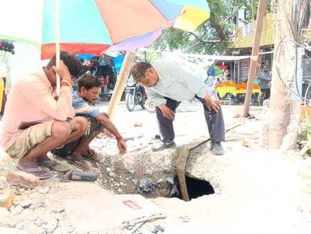 शहर के युवक संघ पुस्तकालय के पास पाइप लाइन सही करते कर्मचारी संवाद