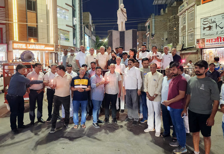 मोमबत्ती जलाकर श्रद्धांजलि देते पदाधिकारी और सदस्य